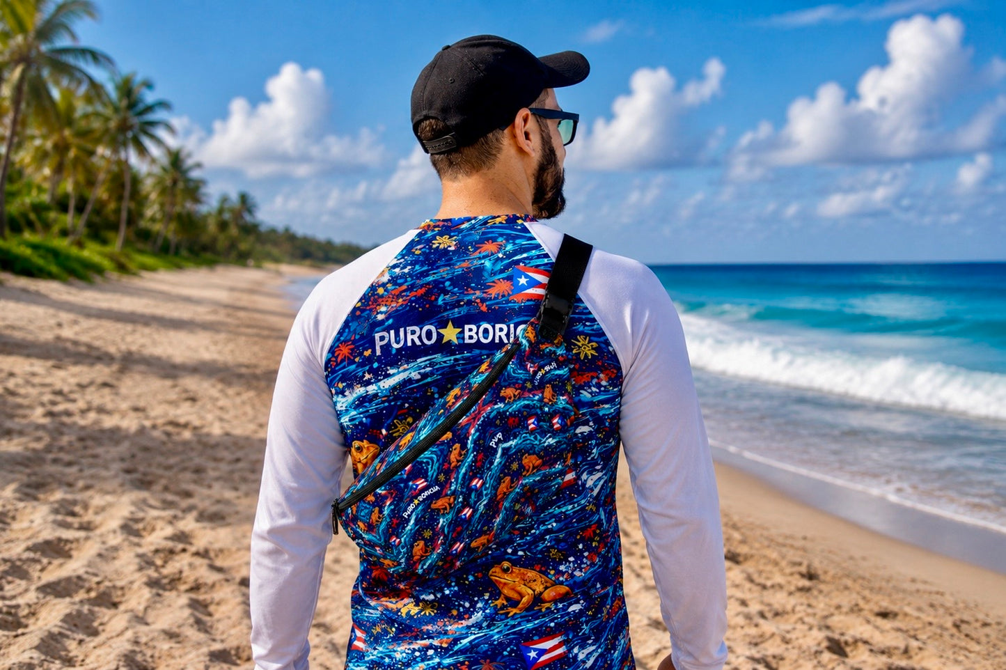 Rear beach lifestyle view of the Pure⭐️Rican Sapo Wave Fanny Pack worn crossbody with matching Puerto Rican inspired rash guard and tropical Sapo Concho frog design.