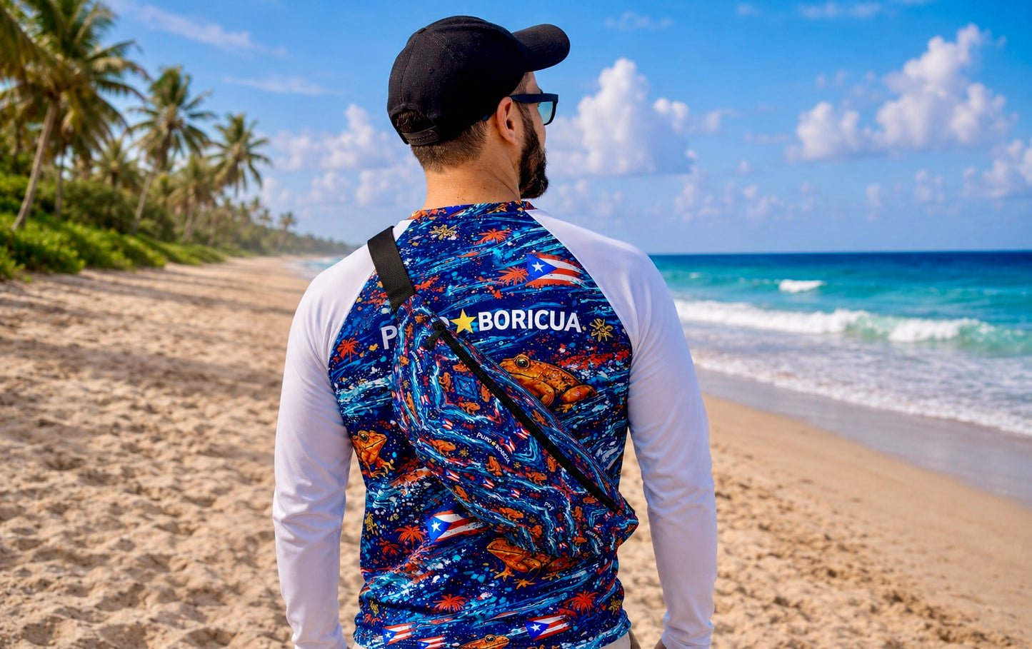 Pure⭐️Rican Sapo Wave Fanny Pack worn crossbody on the beach featuring vibrant Puerto Rican flag accents, ocean-inspired artwork, and signature Sapo Concho frog pattern.
