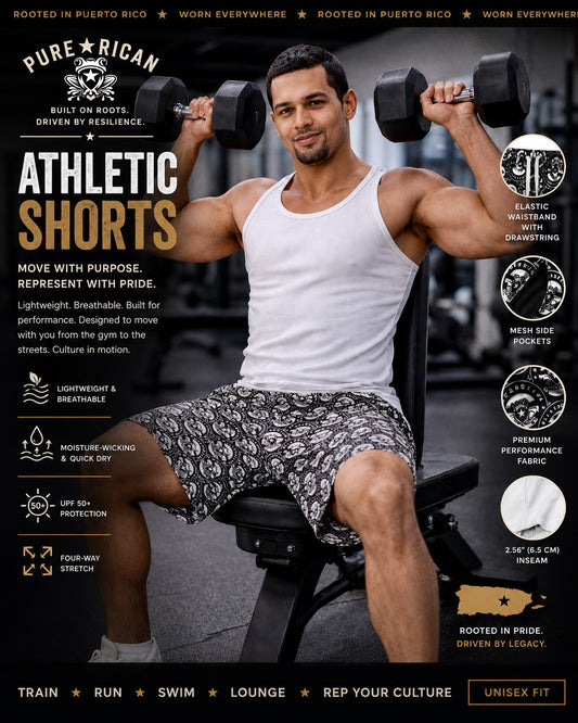 Male fitness model wearing Pure⭐️Rican unisex athletic shorts during a gym workout while lifting dumbbells. Premium lifestyle promotional image featuring black-and-white all-over logo athletic shorts designed for training, running, lounging, swimming, and Puerto Rican-inspired performance streetwear.